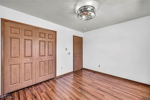 unfurnished bedroom featuring baseboards and wood finished floors
