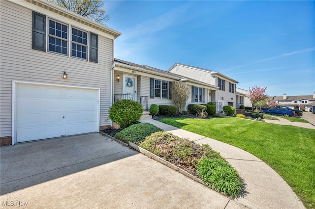 view of front of house with an attached garage, driveway, and a front yard
