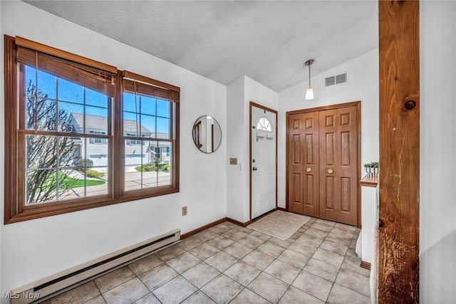 entryway featuring baseboards, light tile patterned floors, lofted ceiling, a baseboard heating unit, and visible vents