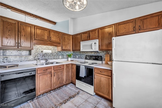 kitchen featuring a textured ceiling, tasteful backsplash, vaulted ceiling, a sink, and white appliances