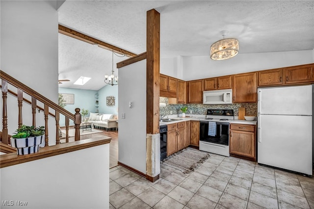 kitchen featuring white appliances, light countertops, a textured ceiling, tasteful backsplash, and lofted ceiling with skylight
