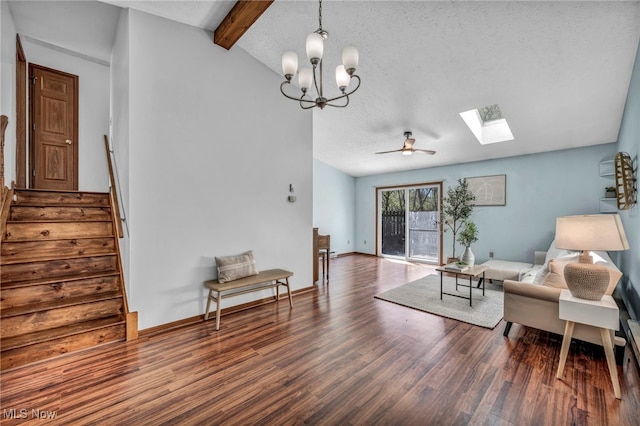 interior space with vaulted ceiling with skylight, a textured ceiling, wood finished floors, stairway, and ceiling fan with notable chandelier