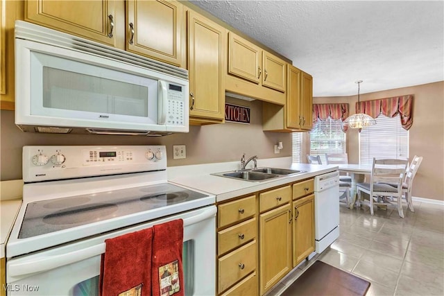 kitchen featuring pendant lighting, a sink, light countertops, light tile patterned floors, and white appliances