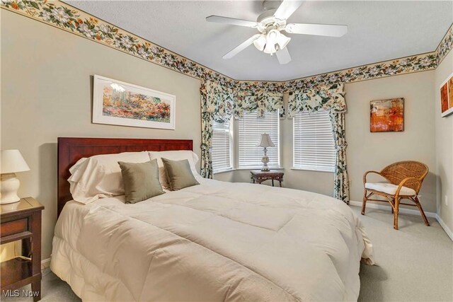 carpeted bedroom featuring baseboards and ceiling fan