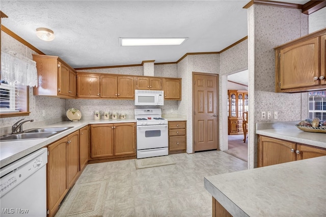 kitchen with crown molding, a sink, white appliances, wallpapered walls, and lofted ceiling