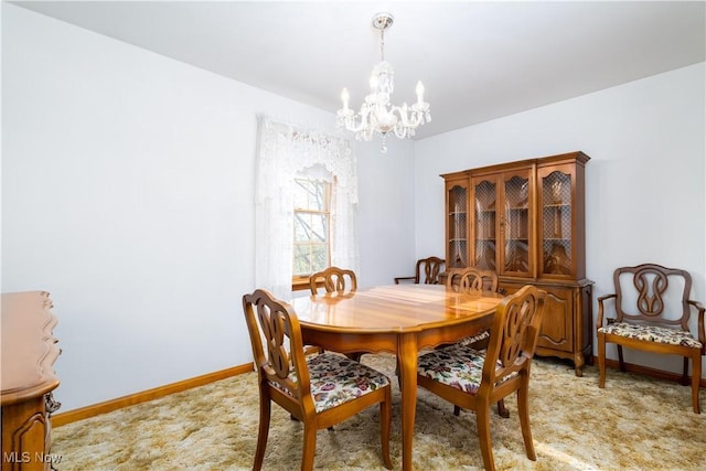 dining room with baseboards, light carpet, and a chandelier