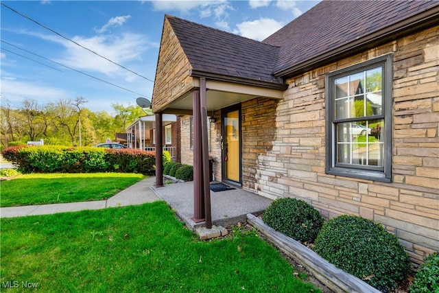 view of property exterior with a yard, a shingled roof, covered porch, and stone siding
