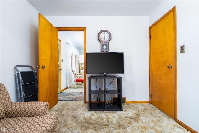 carpeted living area with baseboards
