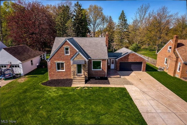 view of front facade with brick siding, a garage, driveway, and a front yard