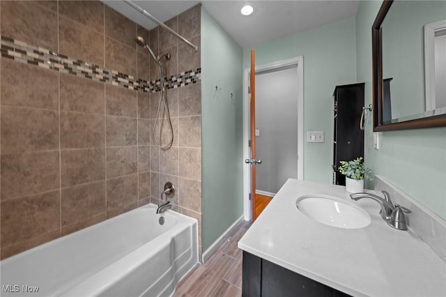 bathroom featuring shower / bath combination, baseboards, wood finished floors, and vanity