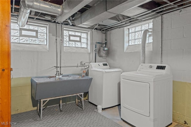 laundry room featuring laundry area, washer and clothes dryer, a sink, and tile patterned floors