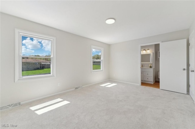 unfurnished bedroom with carpet flooring, baseboards, and visible vents