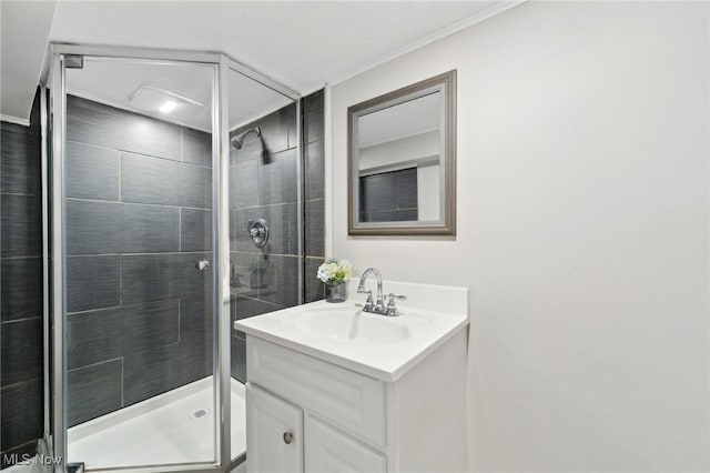full bathroom with crown molding, a shower stall, and vanity