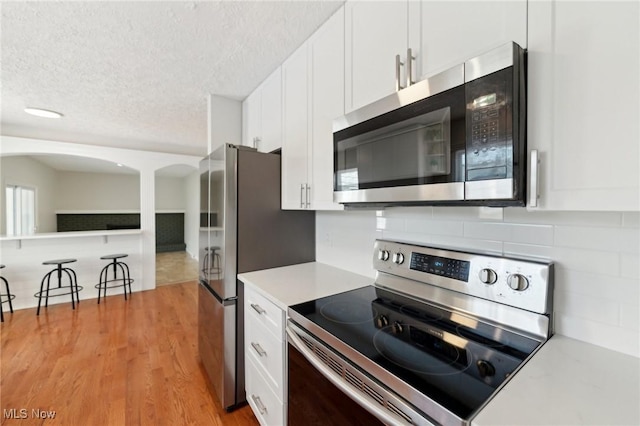 kitchen with light countertops, white cabinetry, a textured ceiling, and appliances with stainless steel finishes