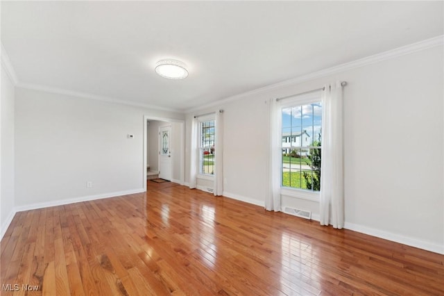 unfurnished room with baseboards, visible vents, ornamental molding, and light wood-type flooring