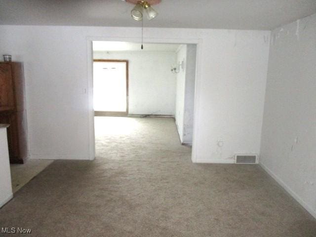 unfurnished room featuring visible vents, carpet, and ceiling fan