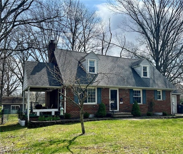 cape cod house with brick siding, a front lawn, and a chimney