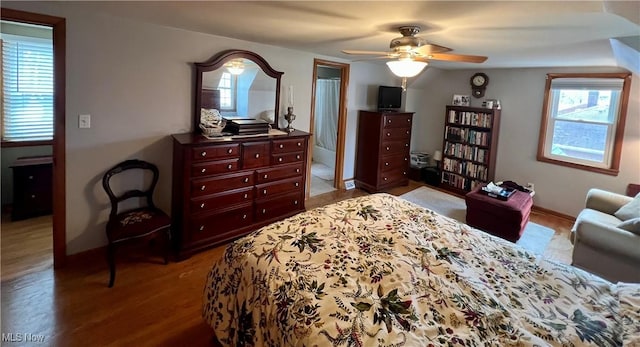 bedroom featuring a ceiling fan, baseboards, and wood finished floors