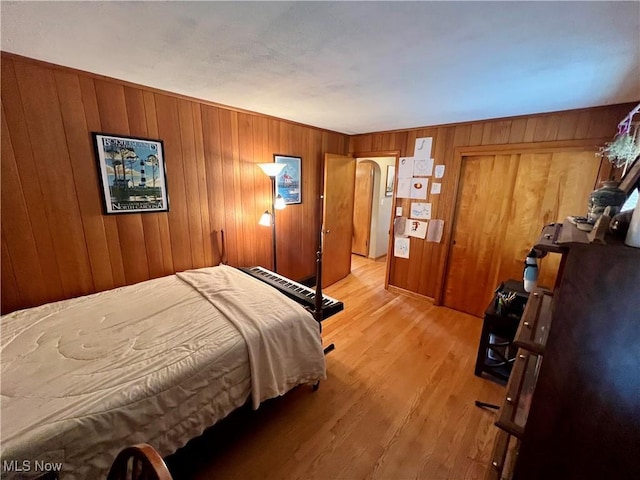 bedroom with wood finished floors and wooden walls