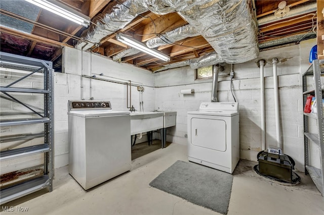 laundry room with washing machine and clothes dryer, laundry area, and a sink