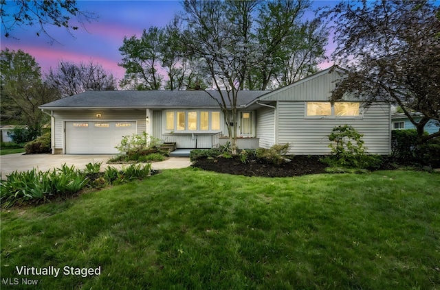ranch-style house featuring a lawn, a garage, board and batten siding, and concrete driveway