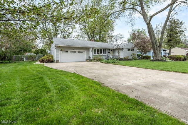 ranch-style home featuring fence, an attached garage, driveway, and a front lawn