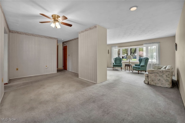 living room with baseboards, a ceiling fan, and carpet floors