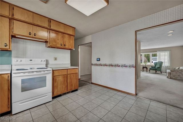 kitchen featuring light countertops, open floor plan, white electric stove, and brown cabinetry
