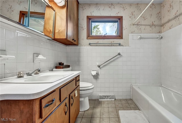 full bath with tile patterned flooring, toilet, a tub, wallpapered walls, and tile walls