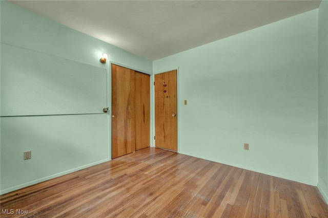 unfurnished room with baseboards and wood finished floors