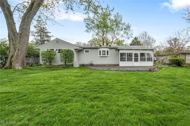 back of house with a yard, fence, and a sunroom