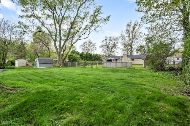 view of yard featuring a fenced backyard, a storage unit, and an outdoor structure