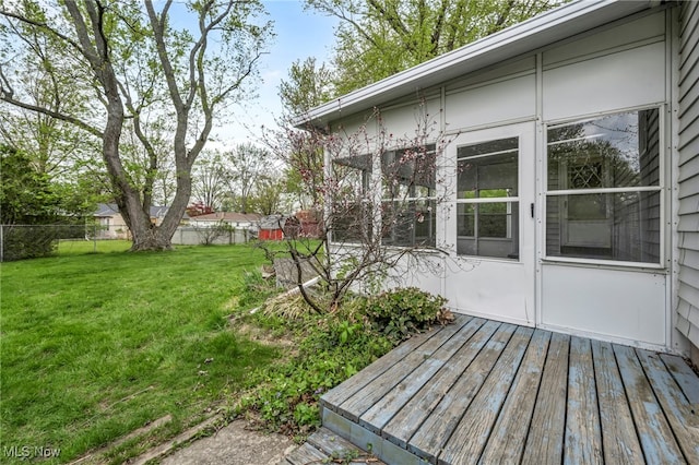 wooden terrace featuring fence and a lawn