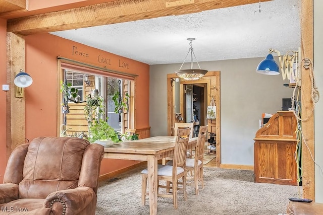 carpeted dining room with baseboards and a textured ceiling