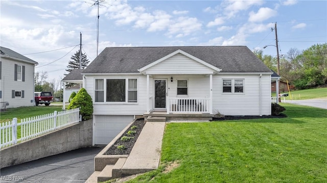 view of front of property featuring fence, a shingled roof, a porch, and a front lawn