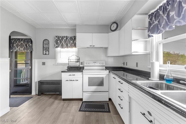 kitchen featuring an ornate ceiling, electric range, white cabinetry, and radiator heating unit