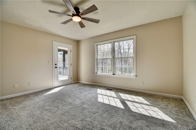 unfurnished room featuring carpet floors, ceiling fan, and baseboards