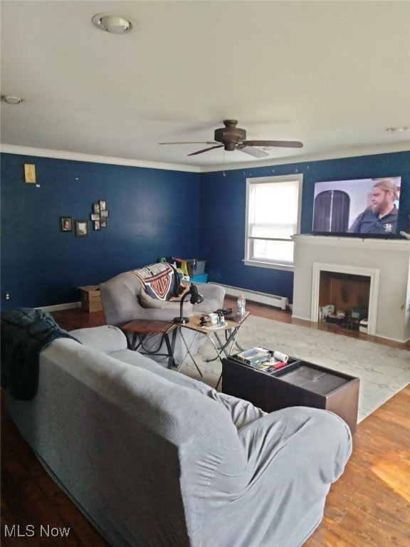 living room featuring baseboards, ceiling fan, baseboard heating, and wood finished floors