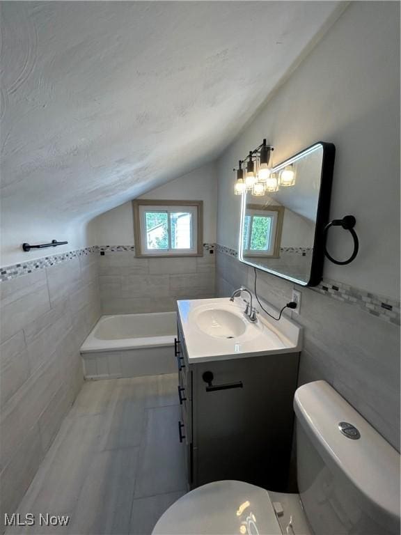 bathroom featuring tile walls, vaulted ceiling, and toilet