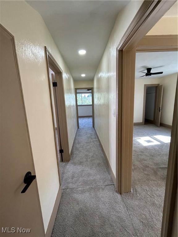 hall featuring recessed lighting, baseboards, and light colored carpet