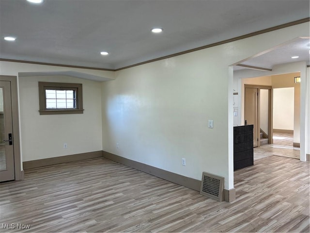 empty room with visible vents, stairs, baseboards, and wood finished floors