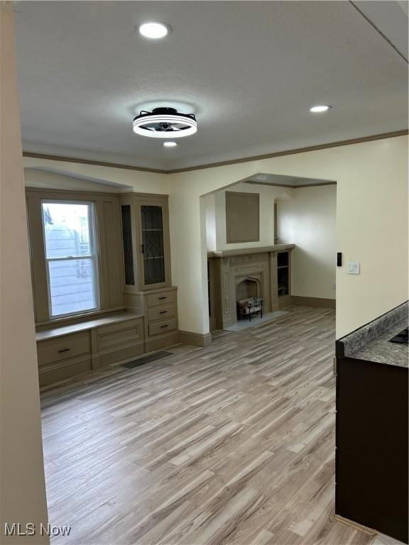 unfurnished living room featuring a fireplace, recessed lighting, baseboards, and light wood-type flooring