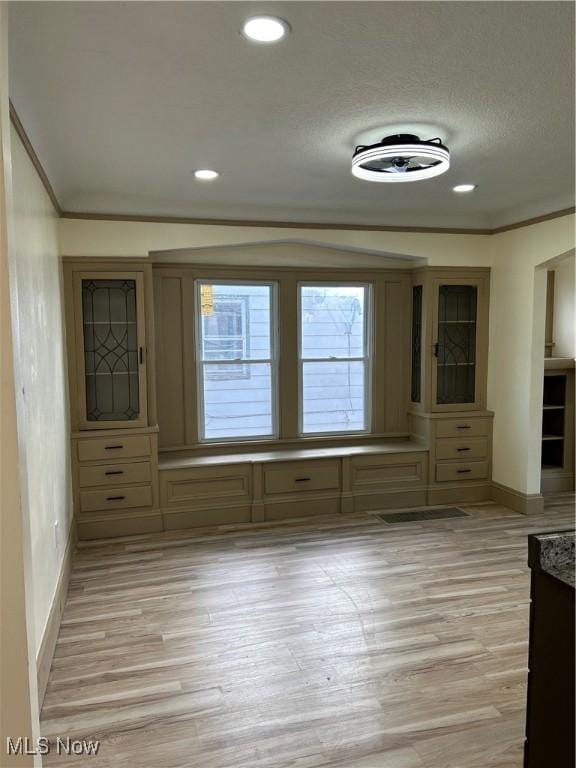 unfurnished dining area with crown molding, baseboards, recessed lighting, and light wood-style flooring