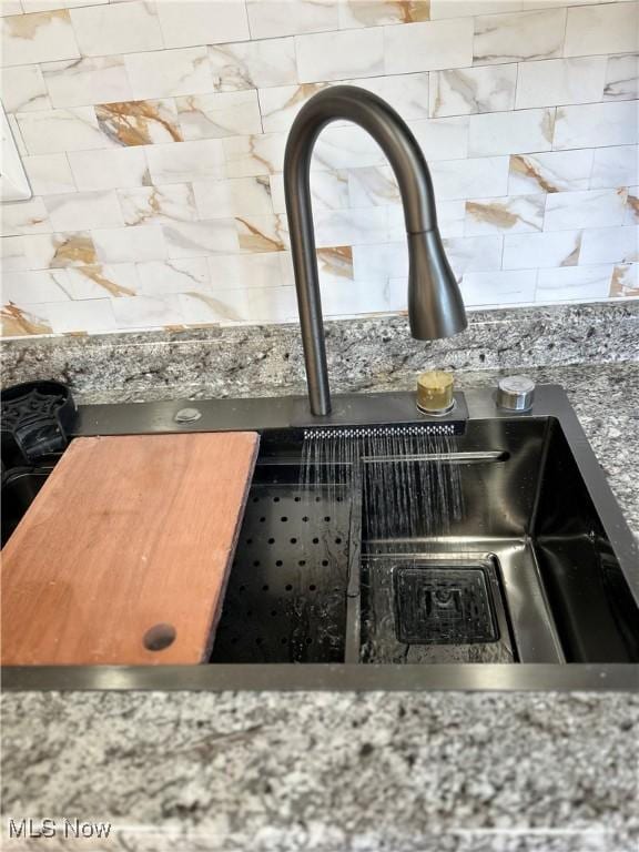 interior details with a sink and tasteful backsplash