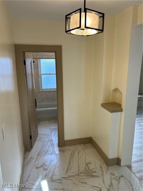 unfurnished dining area featuring baseboards and marble finish floor