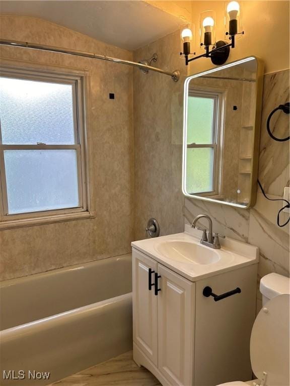 full bathroom with a tub to relax in, an inviting chandelier, toilet, and vanity