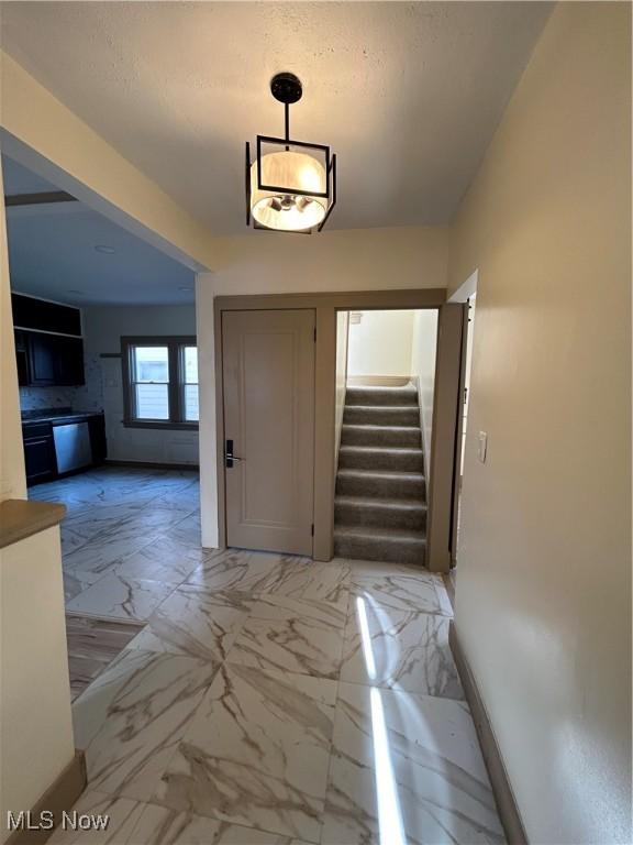 foyer entrance with stairway and marble finish floor