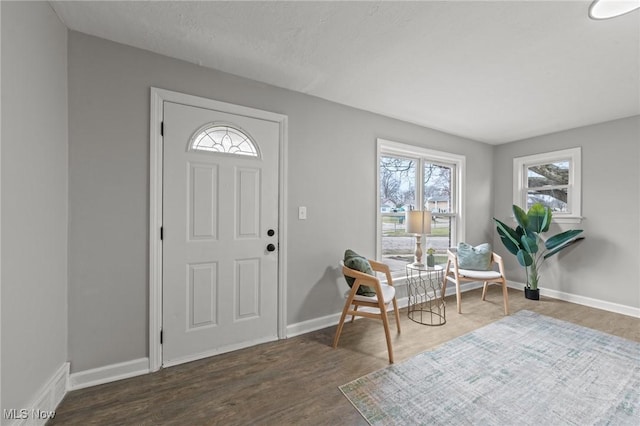 entrance foyer featuring baseboards, visible vents, and wood finished floors