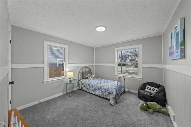 carpeted bedroom with a textured ceiling and baseboards