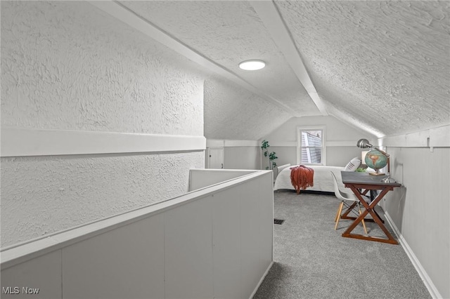 interior space featuring carpet flooring, a textured ceiling, and vaulted ceiling
